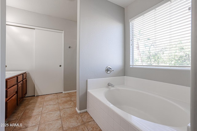 bathroom with tile patterned floors, vanity, and a garden tub