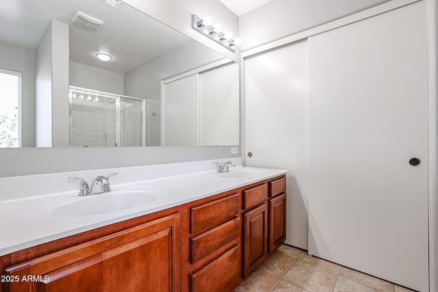 full bath featuring double vanity, a stall shower, visible vents, and a sink