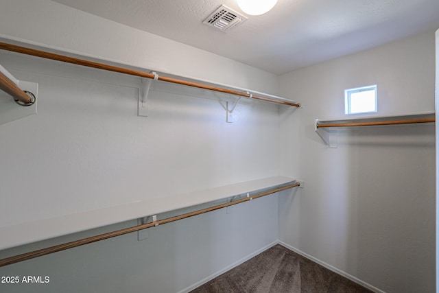 walk in closet with dark colored carpet and visible vents