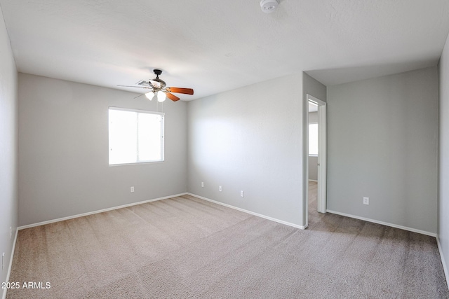 empty room with baseboards, ceiling fan, and carpet floors