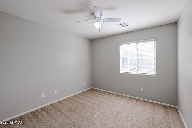 spare room with a ceiling fan, carpet, visible vents, and baseboards