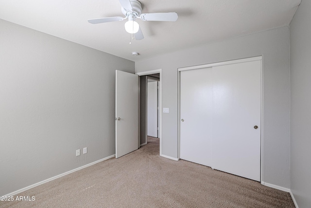 unfurnished bedroom featuring a closet, baseboards, carpet, and a ceiling fan