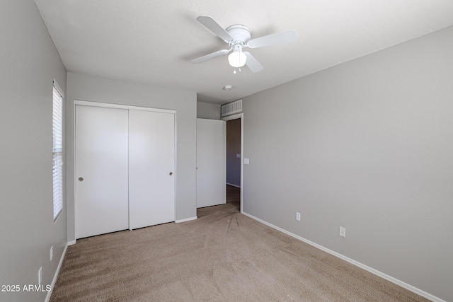 unfurnished bedroom with a closet, visible vents, baseboards, and carpet