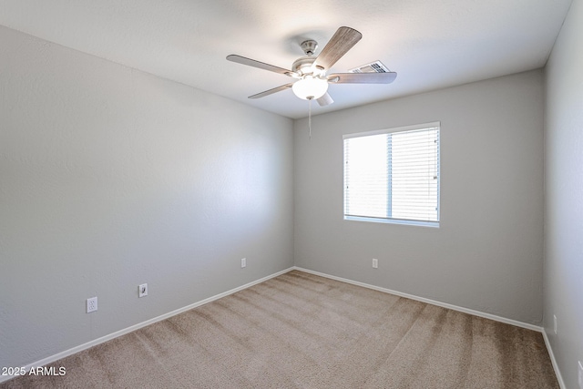 carpeted spare room featuring visible vents, baseboards, and ceiling fan