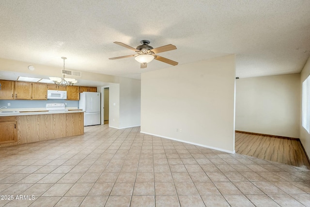 interior space featuring white appliances, visible vents, a peninsula, light countertops, and open floor plan