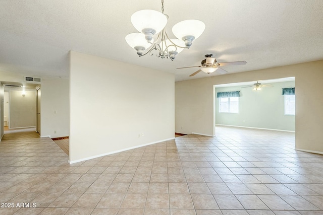 empty room with visible vents, baseboards, light tile patterned floors, ceiling fan with notable chandelier, and a textured ceiling