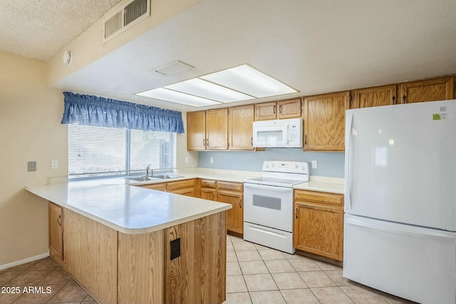 kitchen featuring visible vents, white appliances, a peninsula, and light tile patterned flooring