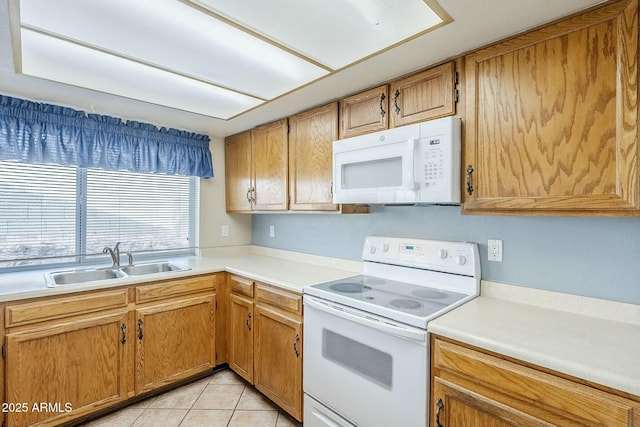 kitchen with a sink, white appliances, light tile patterned flooring, and light countertops