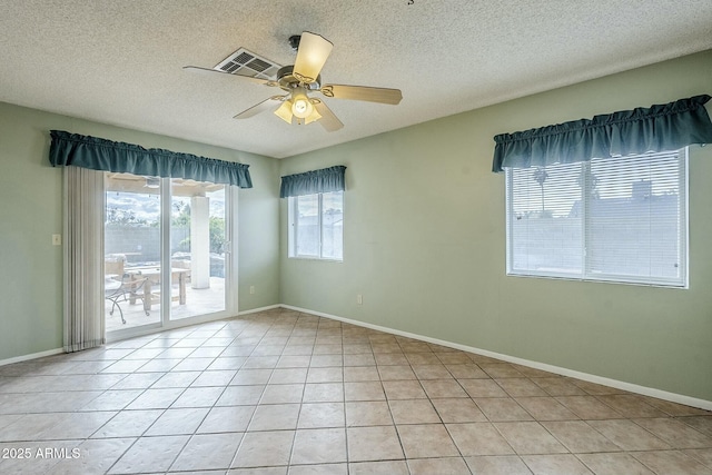 unfurnished room with visible vents, a textured ceiling, light tile patterned flooring, and a ceiling fan