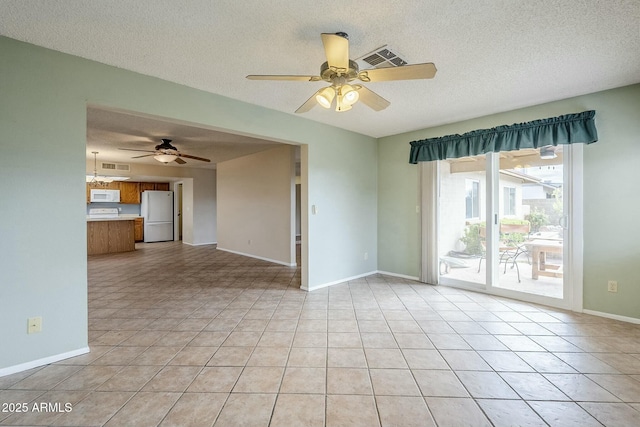 unfurnished room featuring light tile patterned floors, visible vents, baseboards, and a textured ceiling