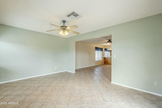 unfurnished room with light tile patterned floors, visible vents, baseboards, and a ceiling fan