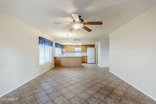 kitchen with visible vents, open floor plan, light countertops, a peninsula, and white appliances