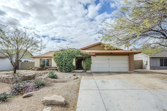 view of front of house with brick siding, concrete driveway, fence, and a garage