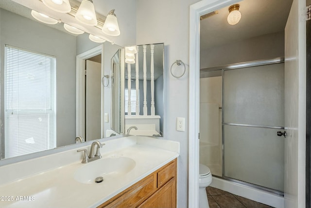 bathroom with tile patterned flooring, visible vents, toilet, a stall shower, and vanity