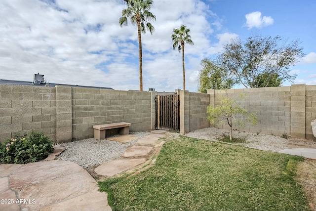 view of yard with a gate and a fenced backyard