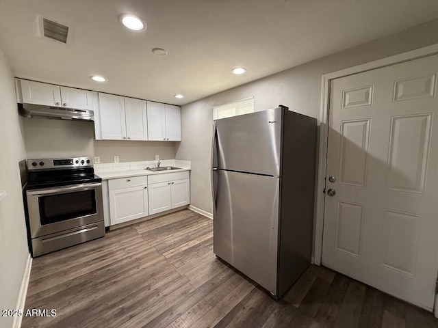 kitchen featuring appliances with stainless steel finishes, white cabinetry, dark hardwood / wood-style floors, and sink