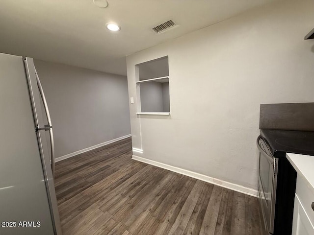 kitchen with stainless steel electric range, white fridge, and dark hardwood / wood-style flooring