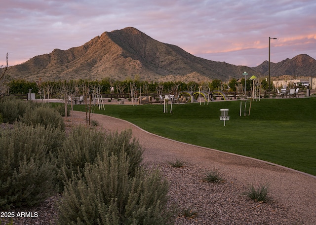 surrounding community with a mountain view and a lawn