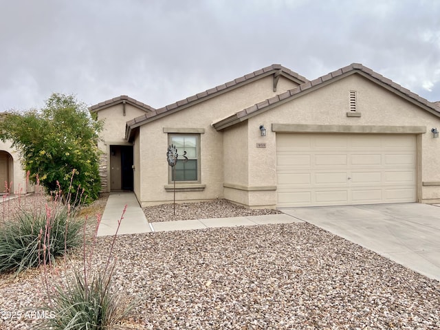 view of front of house featuring stucco siding, an attached garage, a tile roof, and concrete driveway