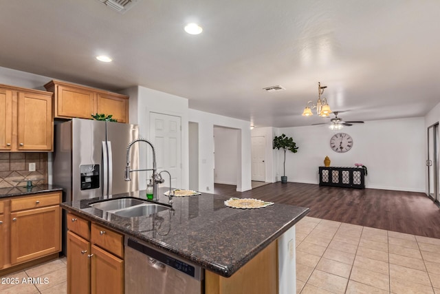 kitchen featuring light tile patterned flooring, a sink, tasteful backsplash, stainless steel appliances, and visible vents