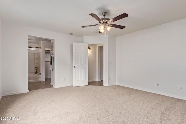 unfurnished bedroom featuring baseboards, ensuite bath, ceiling fan, and carpet