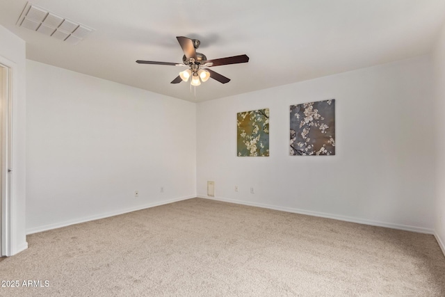 carpeted empty room with baseboards, visible vents, and a ceiling fan