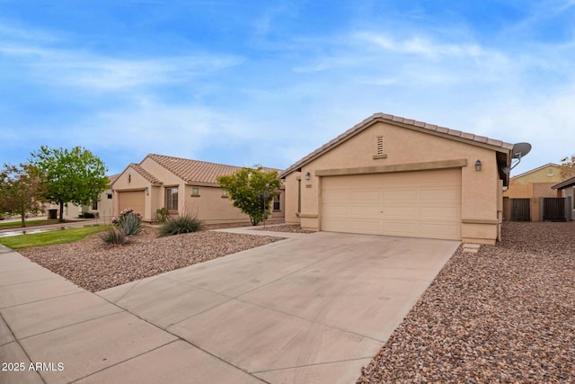 view of front of home with driveway, stucco siding, a garage, and a tiled roof