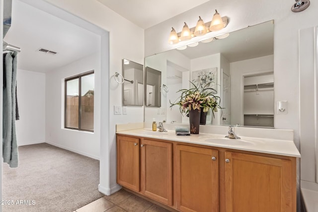 bathroom with visible vents, a sink, tile patterned flooring, and double vanity
