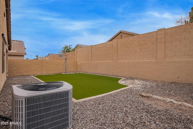 view of yard with central air condition unit and a fenced backyard