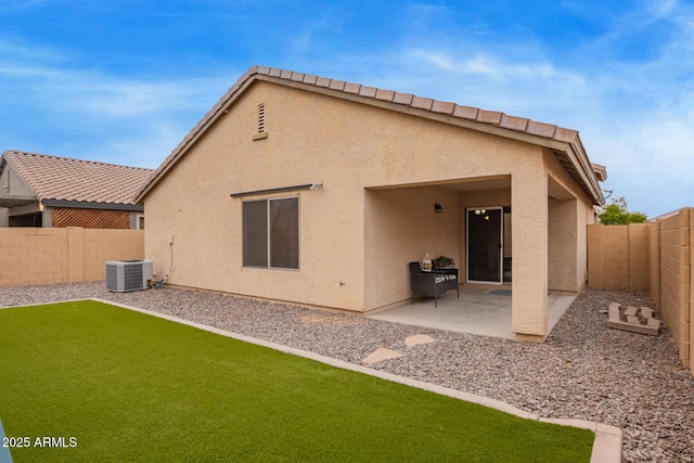 rear view of house featuring stucco siding, a fenced backyard, a patio, central AC, and a yard