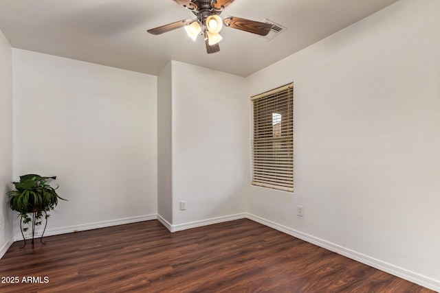 unfurnished room featuring dark wood-style floors, ceiling fan, and baseboards