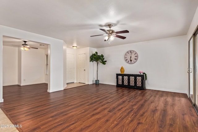 unfurnished room with a ceiling fan, dark wood-style floors, and baseboards