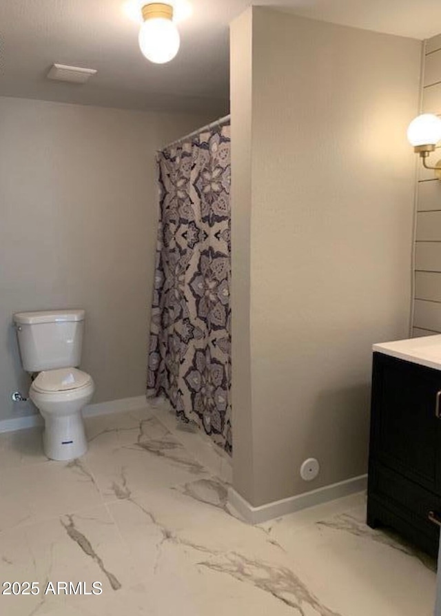 bathroom featuring vanity, toilet, and walk in shower