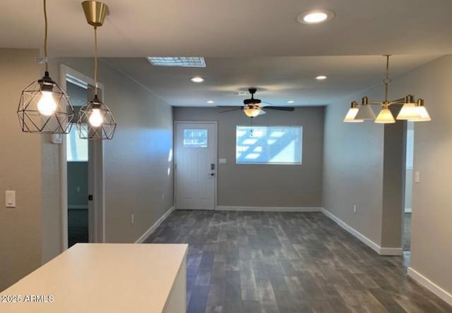 kitchen featuring pendant lighting, ceiling fan with notable chandelier, and dark hardwood / wood-style flooring