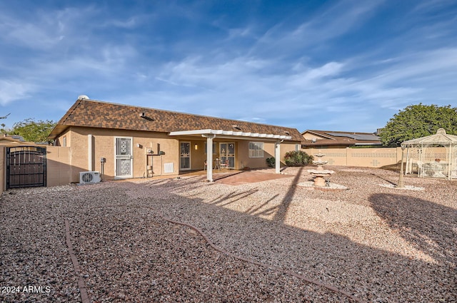 back of property with ac unit and a patio area