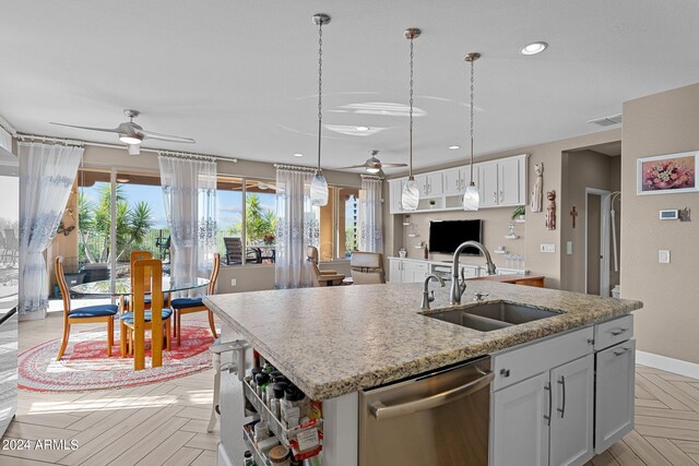 kitchen featuring white cabinetry, an island with sink, sink, light parquet floors, and stainless steel dishwasher