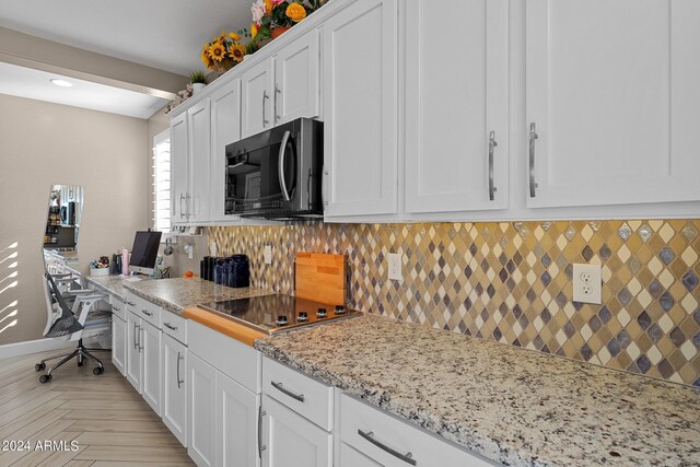 kitchen featuring light stone counters, black electric cooktop, white cabinetry, and tasteful backsplash