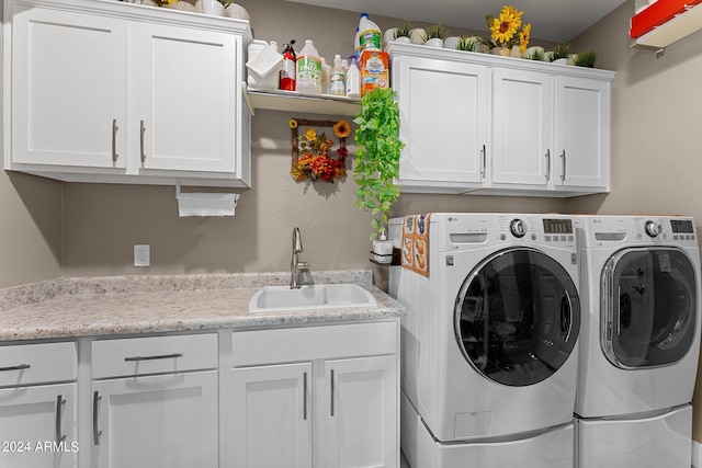 clothes washing area featuring sink, independent washer and dryer, and cabinets