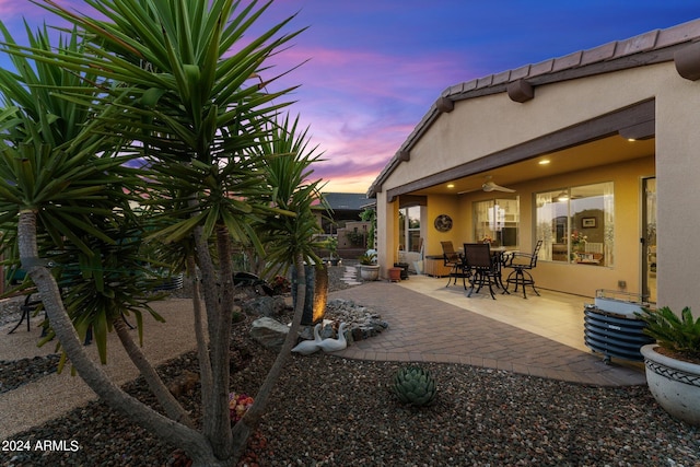 patio terrace at dusk featuring ceiling fan