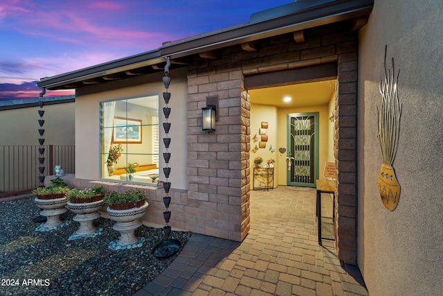 exterior entry at dusk with a patio