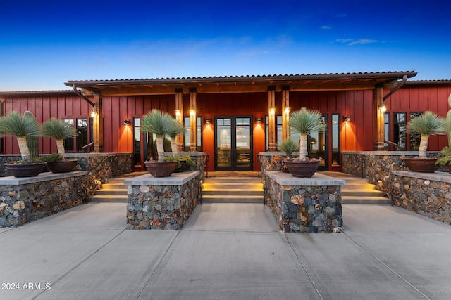 exterior entry at dusk featuring french doors