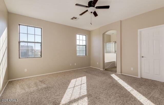 15105 W Glenrosa Ave, Goodyear, AZ 85395 - unfurnished bedroom with arched walkways, carpet floors, baseboards, and ensuite bathroom