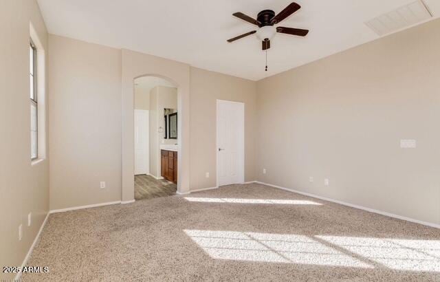 15105 W Glenrosa Ave, Goodyear, AZ 85395 - unfurnished bedroom featuring arched walkways, carpet floors, and baseboards