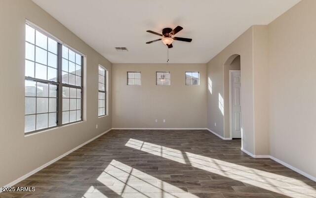 15105 W Glenrosa Ave, Goodyear, AZ 85395 - spare room with dark wood-style floors, ceiling fan, baseboards, and arched walkways