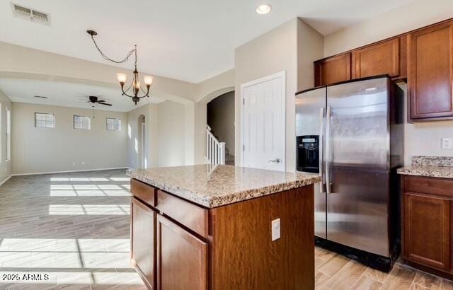 15105 W Glenrosa Ave, Goodyear, AZ 85395 - kitchen with stainless steel refrigerator with ice dispenser, arched walkways, a ceiling fan, light wood finished floors, and a center island