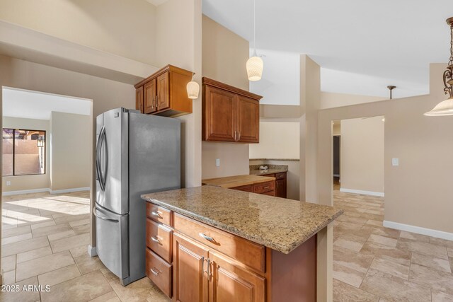 15232 S 36th Pl, Phoenix, AZ 85044 - kitchen featuring freestanding refrigerator, high vaulted ceiling, light stone countertops, brown cabinets, and a peninsula