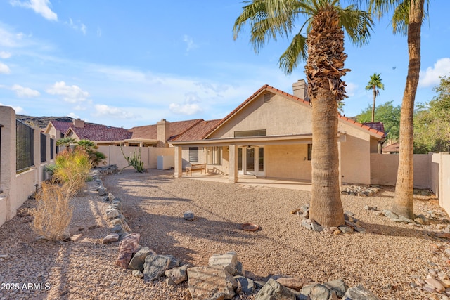 15232 S 36th Pl, Phoenix, AZ 85044 - back of house with stucco siding, a chimney, a fenced backyard, a tiled roof, and a patio area