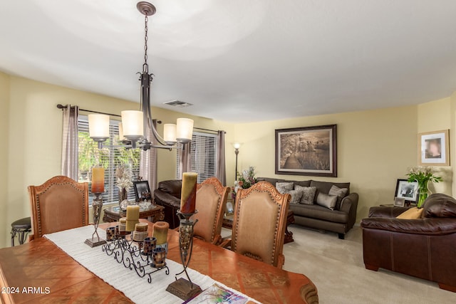 living room featuring light carpet and a notable chandelier