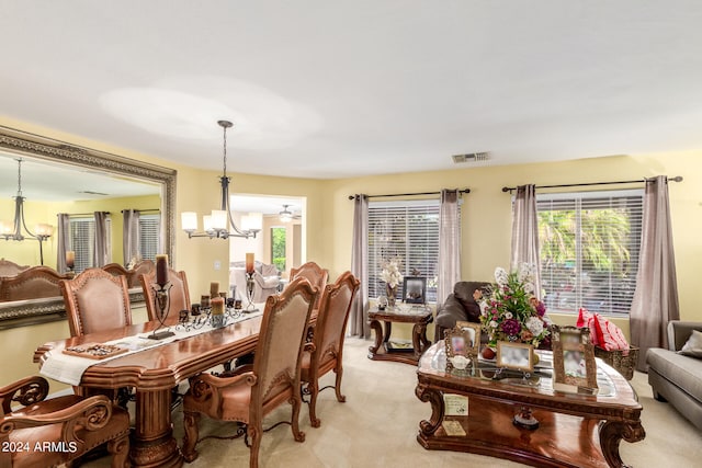 dining area with a wealth of natural light, an inviting chandelier, and light carpet