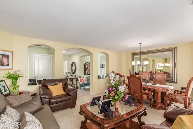 carpeted living room with an inviting chandelier